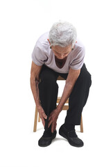 senior woman sitting with foot pain white background