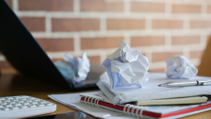 close up on crumpled paper sheet on the table with stationery for mental burnout and overworked...