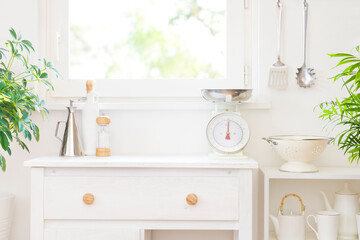 Naklejka na ściany i meble Kitchen furniture beside window with various utensils arranged on shelves