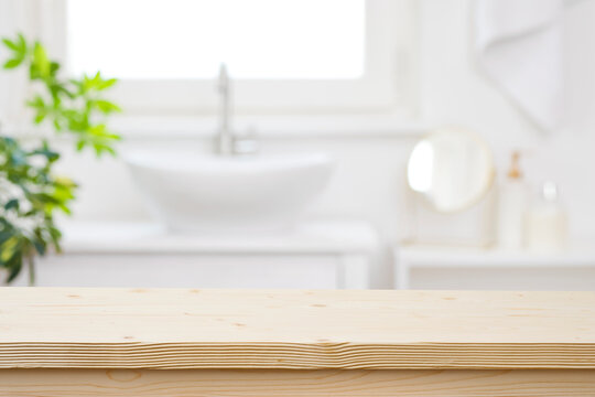 Blurred bathroom hand washing corner with wooden table in front