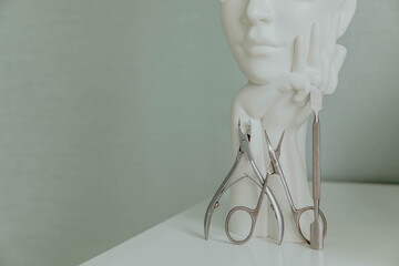Manicure tools on a light background with a sculptural vase