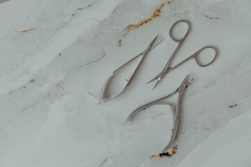 Manicure tools on a light marble background
