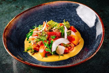 Shrimps salad with arugula, mango and coconut in bowl