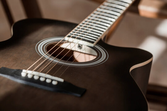 Guitar. Guitar chords. Acoustic guitar. Music. Musical background. An image of an acoustic guitar. Hard light. Shadows.