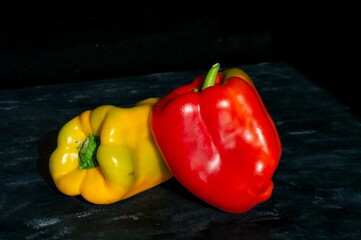 red and yellow bell peppers, on a black background