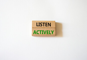 Listen actively symbol. Wooden blocks with words Listen actively. Beautiful white background....