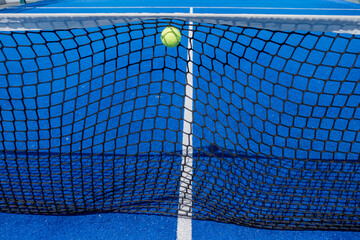 ball hits the net of a paddle tennis court