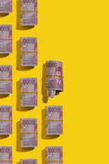 Indonesian rupiah rolls on yellow background