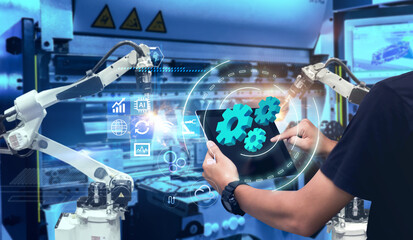 Automation smart robotic industry 4.0 concept.Man hands pointing at virtual blue gears on blurred robot arm and factory as background