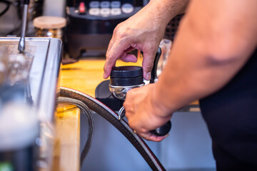 Banner of Asian Barista tamping the portafilter and preparing cup of coffee, espresso with latte or cappuccino for customer order in coffee shop,Small business owner and startup in coffee shop concept