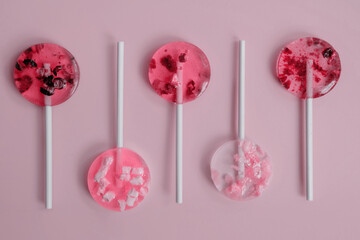 soft pink homemade fruit lollipops with pieces of fruit lie in a checkerboard pattern