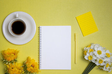 To do list concept with a blank paper, coffee, flowers and coffee over the yellow background.
