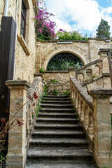Fototapeta na wymiar Selective focus on beautiful stone staircase with arched side walls, greenery and flowers in the old town of Kyrenia or Girne, Northern Cyprus.