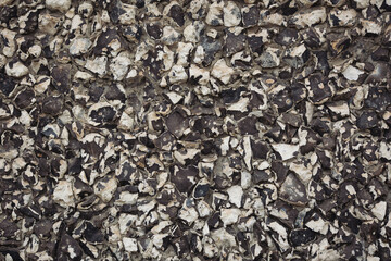 Close up shot of a beautifully textured dry stone wall. Old, rough, gray stone wall background texture. Masonry texture of natural gray stone. Dark stones and rocks of different shape.