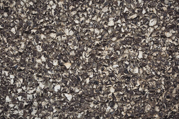 Close up shot of a beautifully textured dry stone wall. Old, rough, gray stone wall background texture. Masonry texture of natural gray stone. Dark stones and rocks of different shape.