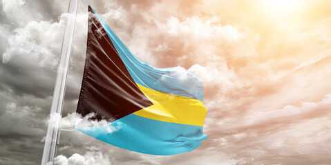 The Bahamas national flag cloth fabric waving on beautiful Cloudy Background.