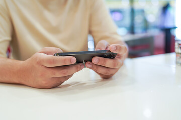 Man playing game on mobile phone. gamer boy playing video games holding Smartphone working mobile devices. cell telephone technology e-commerce concept
