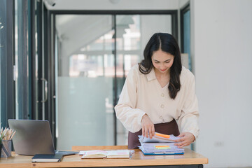 Young Indian Accountant Woman in casuals working on financial analysis documents with a tense...