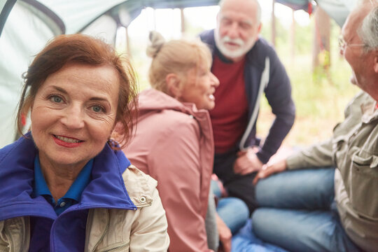 Senior woman with friends in tent at campsite