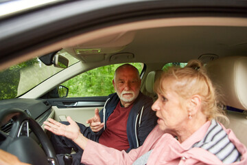 Elderly couple traveling in car during vacation
