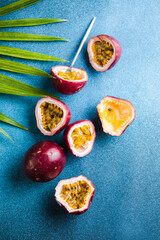 Ripe passion fruit, half and slice of fruit on a blue background.