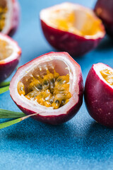 Ripe passion fruit, half and slice of fruit on a blue background.