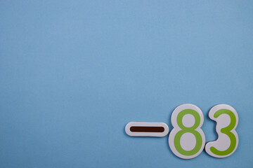 Colorful number -83, placed on the edge of a blue background.