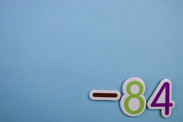 Colorful number -84, placed on the edge of a blue background.