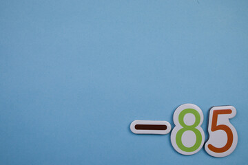 Colorful number -85, placed on the edge of a blue background.