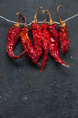 Top view of dried hot red peppers on black background with free space