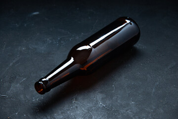 Top view of empty open glass bottle laid on table on black background with free space