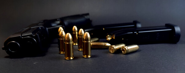 Gun and cartridges on a dark background, close-up of cartridges - obrazy, fototapety, plakaty
