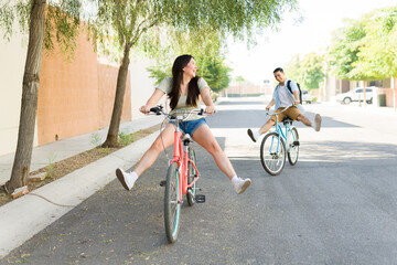 Attractive girlfriend having fun with her boyfriend going on a bike ride