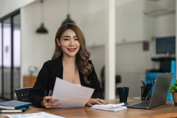 Young asian business woman analysis finance graph company budget report