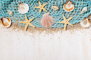 Net with seashells and starfish on a white wooden jetty