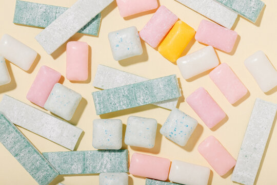 Various types of mint and fruit gum on a yellow background top view