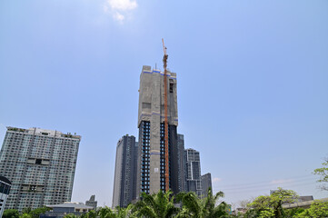 Fototapeta premium BANGKOK, THAILAND - June 20, 2023 : The construction of new building in the city with blue sky background in the city. Construction Concept in Thailand.
