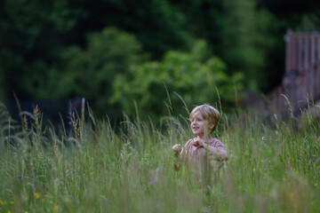 Happy boy playing and running on a meadow.