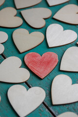 Obraz premium Love Valentines day background, group of light wooden hearts spread on vintage blue green scratched table, flat lay one by one