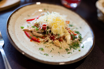 Plate with with chicken, vegetables and grated cheese close up
