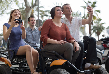 family of tourists enjoy a walk on the bike carriage
