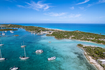 Drone aerial view of anchored sailing yacht in emerald Caribbean Sea, Stocking Island, Great Exuma,...