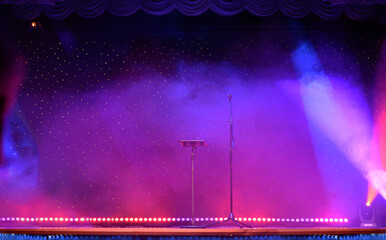 Elegant theatre show with colored spotlights and microphone
