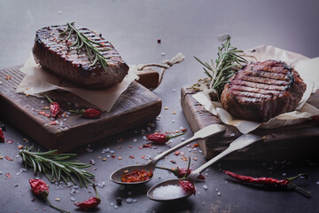grilled  beef meat Burger steak cutlets with seasoning on vintage wooden boards, black background