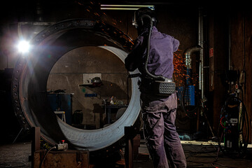 Obraz na płótnie Canvas Steelworkers working with steelproducts at plant. welding and inspection - Wind turbine industry