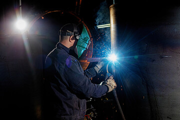 Steelworkers working with steelproducts at plant. welding and inspection - Wind turbine industry
