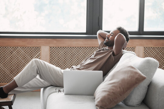 Satisfied Handsome Young Man Relaxing On The Sofa At Home, Smiling Men Enjoying Day Off Lying On The Couch, Healthy Lifestyle, People And Holiday Concept