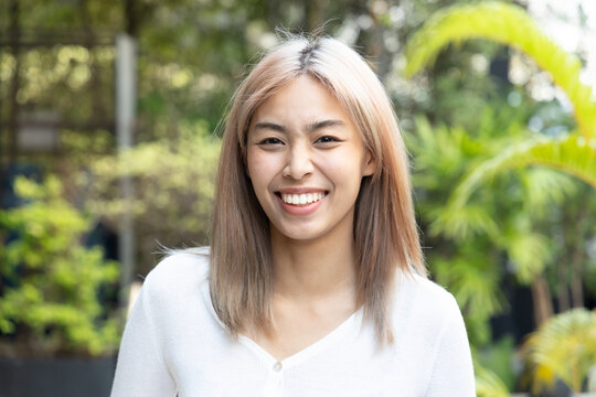 Happy smiling southeast asian woman with modern hair coloring
