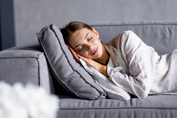 Young attractive woman sleeping on the couch in the living room