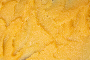 The texture of a yellow fruit sugar body scrub. Flat lay, selective focus